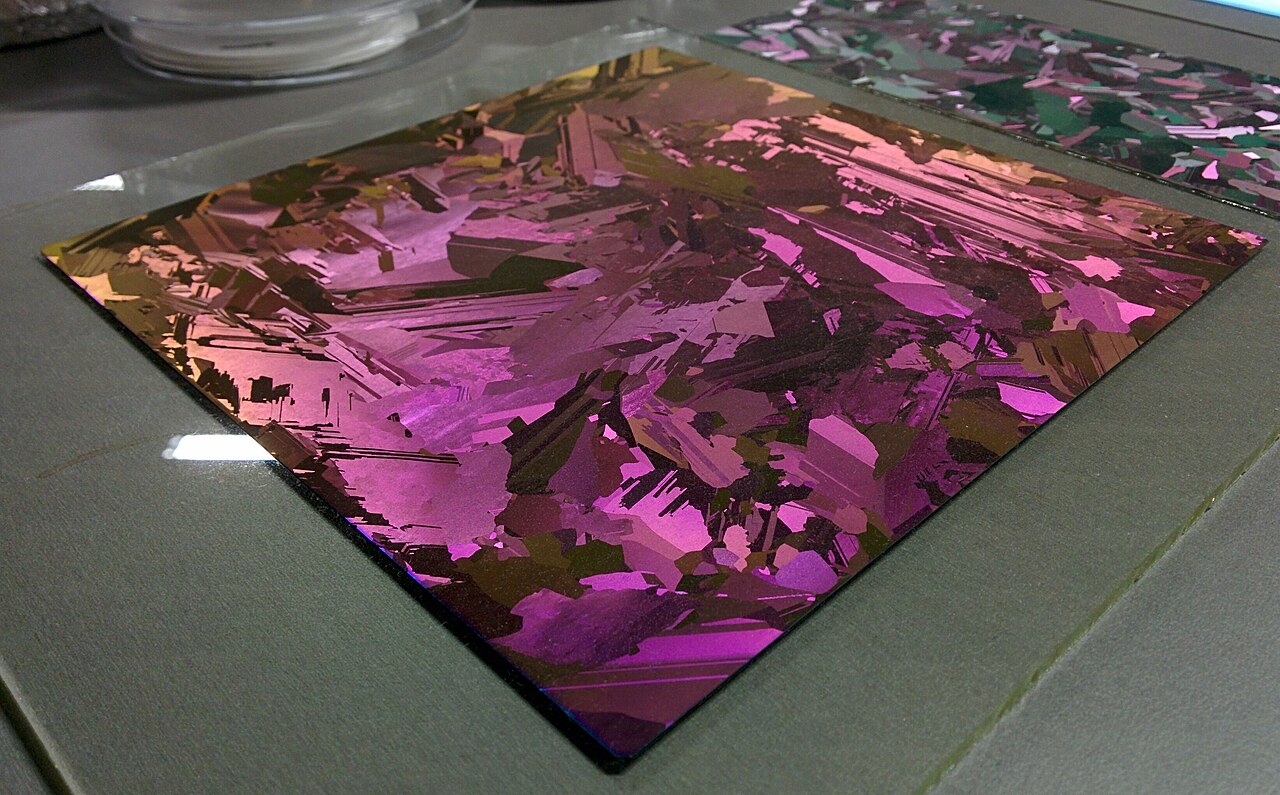 A silicon wafer with an iridescent thin-film surface, shimmering in rainbow colours