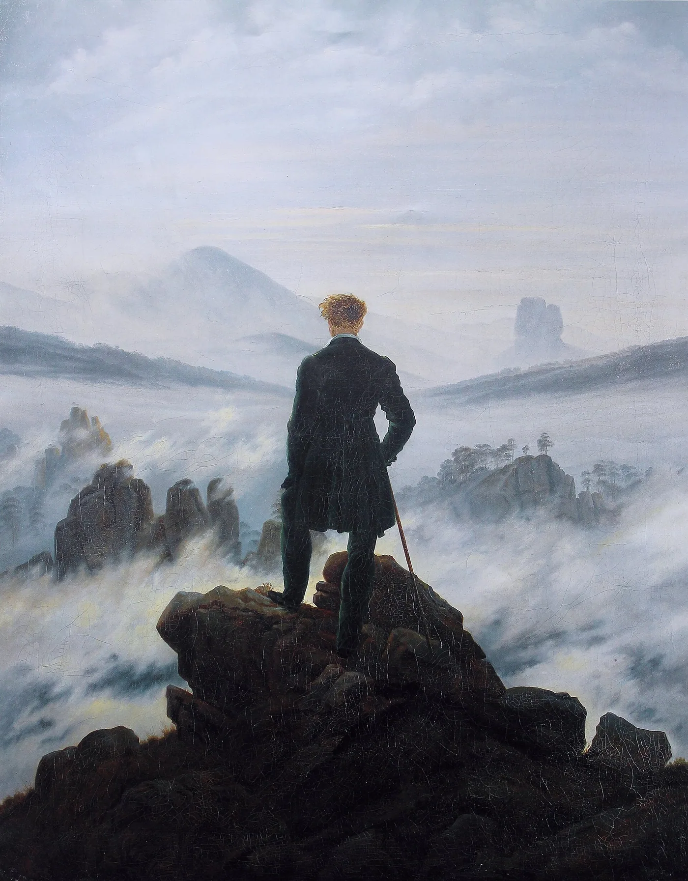 A lone figure with a walking stick looks across the mist-covered mountains in Friedrich’s Wanderer above the Sea of Fog.