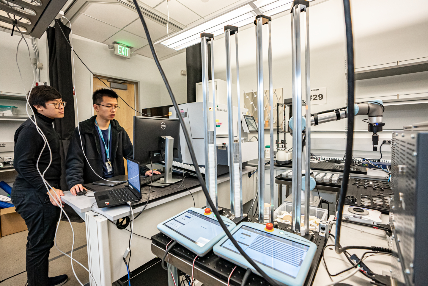 Researchers beside the robot arm, sample trays and instruments of Berkeley Lab’s A-Lab.
