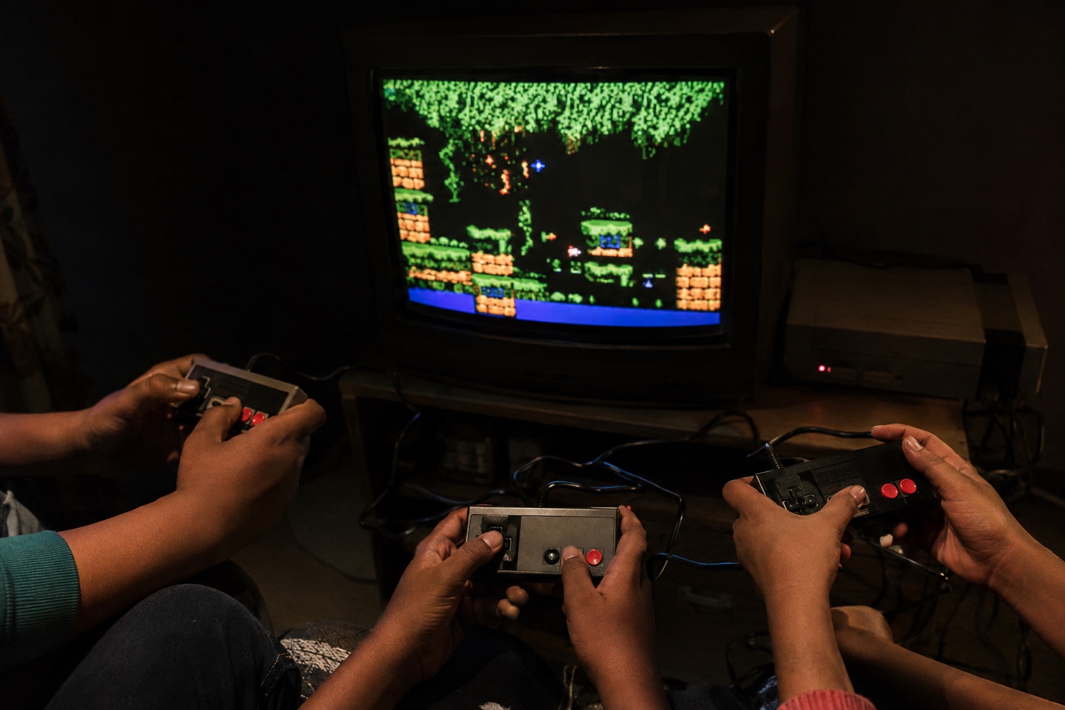 An imagined scene of several children holding wired controllers in front of a CRT showing an original pixel-art jungle game.