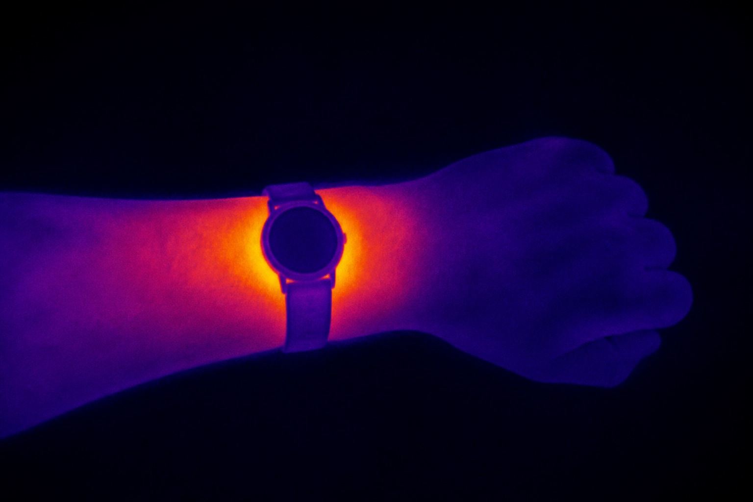 An imagined thermal-style image of a wrist and watch with heat concentrated beneath the case
